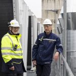 danny van der velden van equans refrigeration nederland en rindert meerstra van gasunie kijken in de camera met buizen van de stikstofinstallatie op de achtergrond