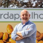 Bart Nemegheer staat lachend voor logo Aardappelhoeve