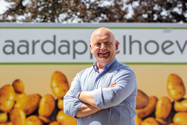 Bart Nemegheer staat lachend voor logo Aardappelhoeve